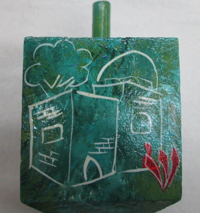 Hanukah Dreidel Painted Wood Sevivon hand painted with green background and designs. Dimension 5 cm X 5 cm X 10 cm approximately.