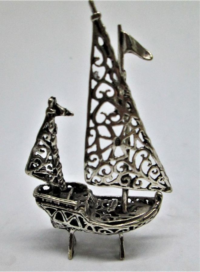 A handmade sterling silver miniature Cutout sailing boat Sculpture with two sailing poles. Dimension 4.4 cm X 1.5 cm X 7.5 cm approximately.