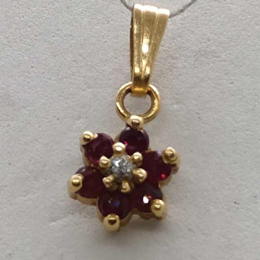 14 carat yellow gold star Magen David Diamond Rubies pendant set with a genuine white diamond 4 pts & 6 rubies, 0.6 cm X 0.7 cm X 0.03 cm.
