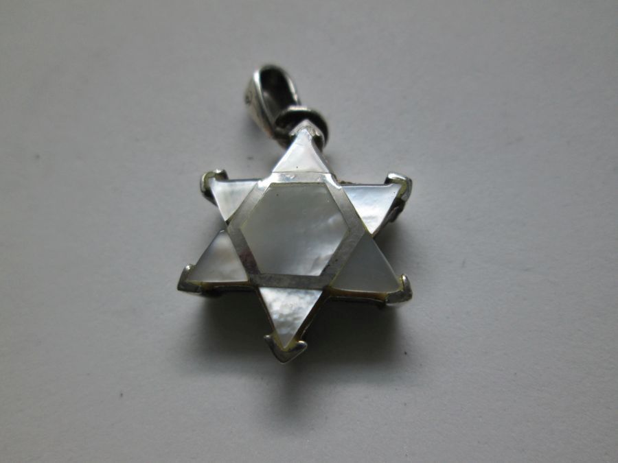 Sterling Silver Mother Pearl David Star Pendant handmade. Sterling silver mother pearl David star pendant with triangle pieces of mother of pearl forming the star. Dimension 1.7 cm X 2.6 cm approximately. One can find a wide variety of star of David pendants in silver , gold and other cheaper materials. There are designs for women ,men and children different sizes to suit every desire. Star of David is known in Hebrew Magen David or the Shield of David is a generally recognized symbol of modern Jewish identity and Judaism. Its shape is made by 2 triangles forming a hexagram, combination of two equilateral triangles. The star of David has been adapted into a variety of many culture, but in different meanings. Nowadays it is symbolizing the state of Israel's flag since the first Zionist congress in 1897. Before that it was used in Christianity to decorate churches in medieval time. Only later 19th century it has been used by eastern European Jewish communities as their Jewish symbol. The Zohar (Kabbalah) gives a spiritual explanation as for the star of David triangles. The first triangle has the connection of G-D , Torah and The sons of Israel. The second triangle is reflected by G-D , the study of Torah and the study of the Zohar. By doing these learning the Torah and the Zohar you approach yourself to G-D. The fact that in a triangle each of The three corners of the triangles are connected with each other . It demonstrates that the Jewish soul is itself knotted to G‑d Through the Torah study and observance. By that connection between the Jew and G‑d and the Torah study it merely brings it to light. Visit my eBay site :PENDANT STERLING SILVER STAR OF DAVID PENDANT MASCULINE HEAVY LOOK Facebook connection : Y.Sh.Ghatan & Sons For gold Star of David :Star of David Gold Pendants