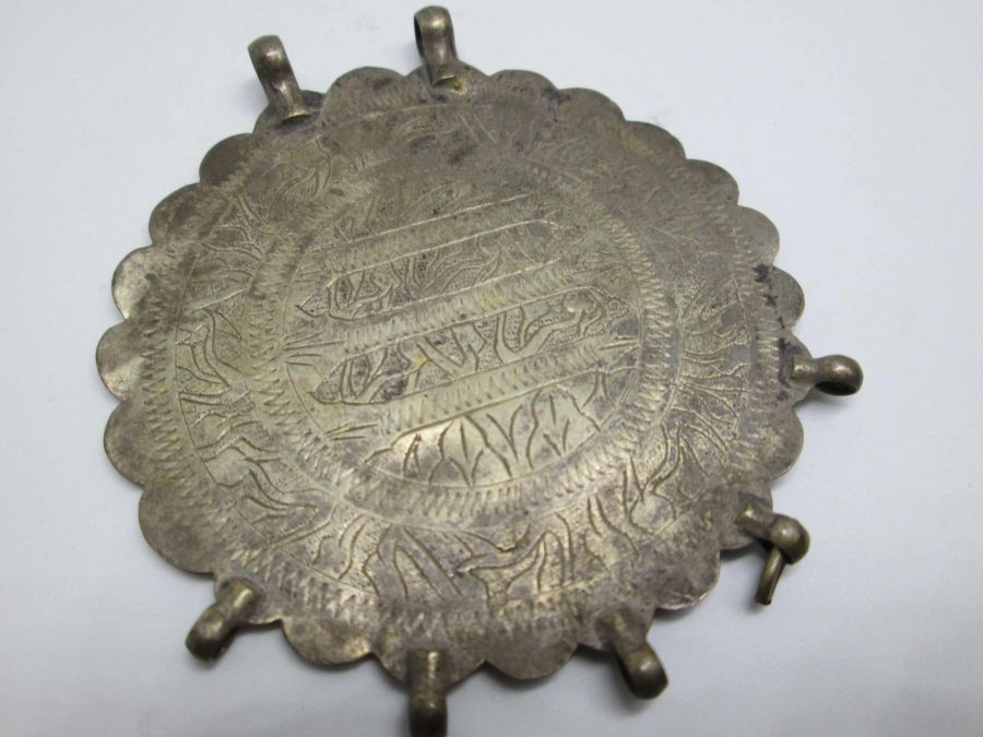 Handmade amulet pendant silver vintage made by nomads set with engravings Arabic words in center Middle East nomad’s jewelry.