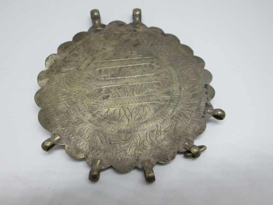 Handmade amulet pendant silver vintage made by nomads set with engravings Arabic words in center Middle East nomad’s jewelry.