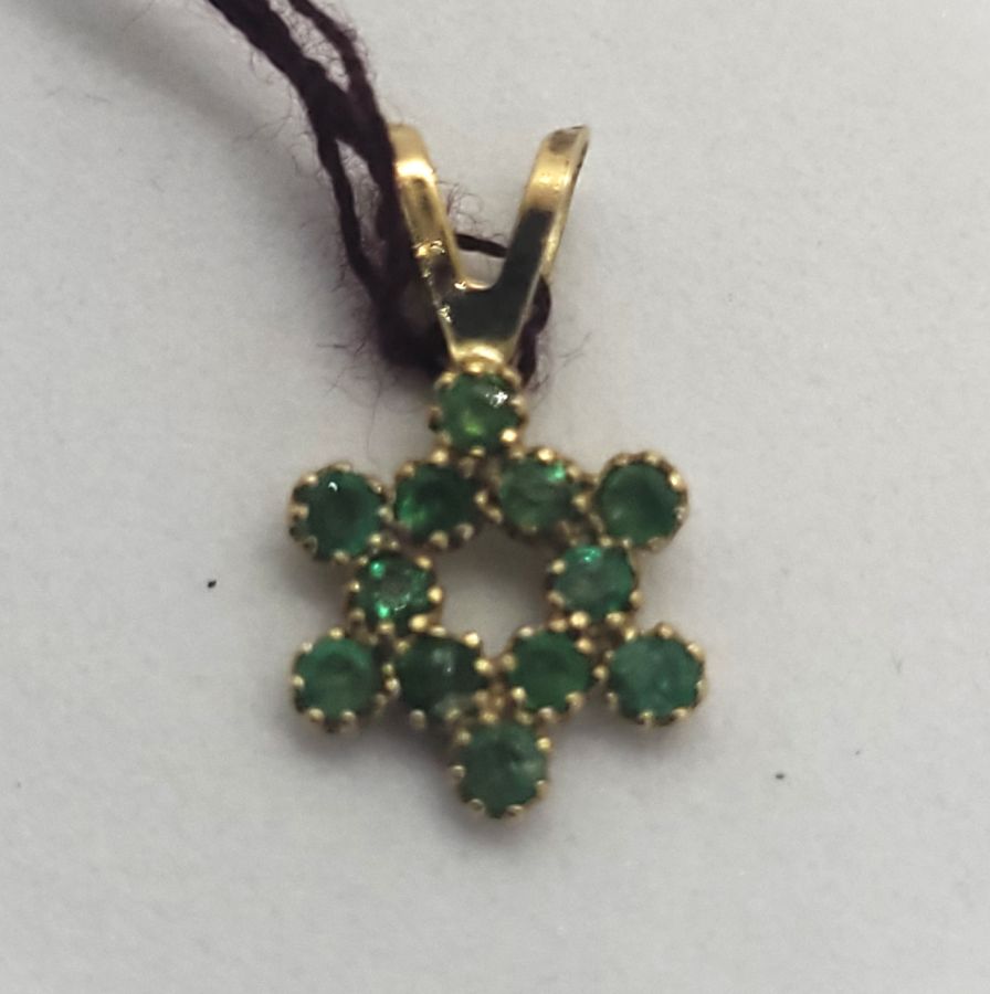Handmade 14 carat gold 12 Emeralds Magen David star pendant set in and forming a star of David 1.35 cm X 0.8 cm X 0.1 cm approximately.