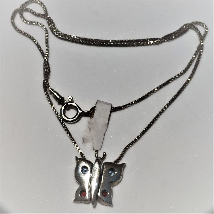Sterling silver pendant puzzle butterfly three separated parts forming a butterfly and set with blue Topaz and Garnet stones.