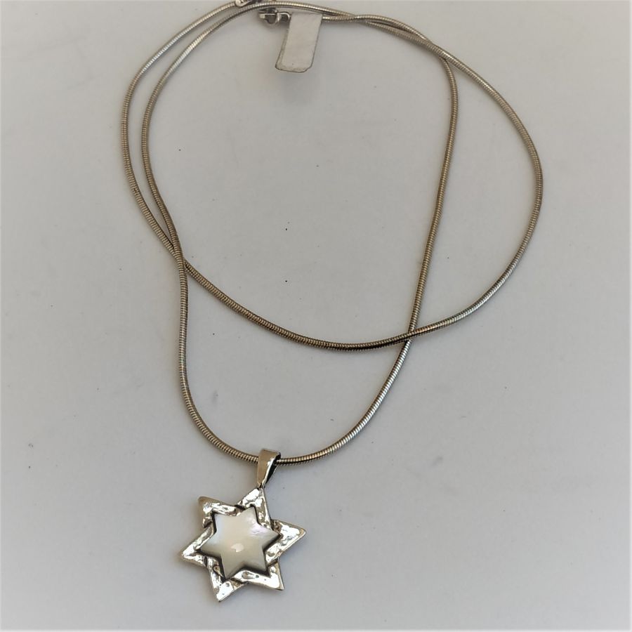 The jeweler has set in the star of David Magen David Mother ofPearl a mother of pearl in center of star 2.4 cm X 1.6 cm X 0.35 cm.
