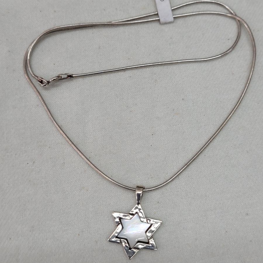 The jeweler has set in the star of David Magen David Mother ofPearl a mother of pearl in center of star 2.4 cm X 1.6 cm X 0.35 cm.