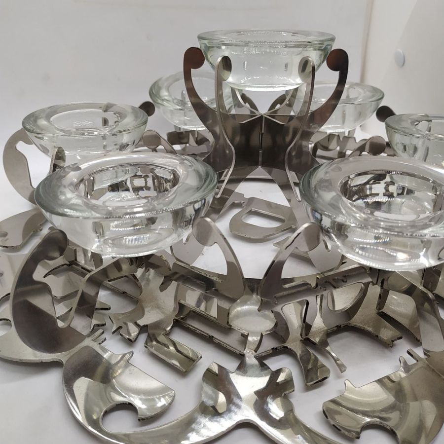 The laser cut Passover dish stainless steel design are the names of the food cut out and distinguished. Numbered & signed by artist diameter 35 cm X 15 cm.