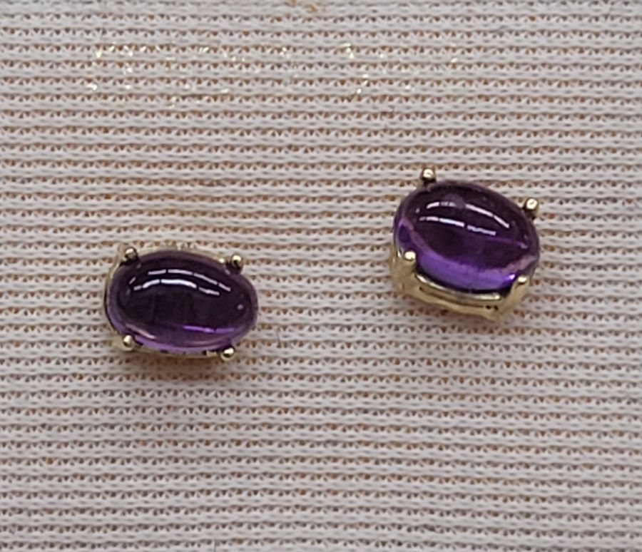Handmade 14 carat gold cabochon Amethyst stud earrings set with two cabochon purple Amethyst stones handmade. Dimension 0.4 cm X 0.6 cm approximately.