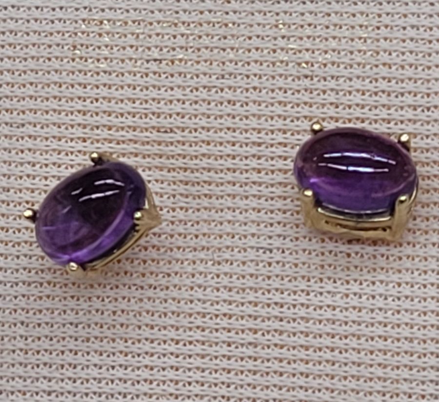 Handmade 14 carat gold cabochon Amethyst stud earrings set with two cabochon purple Amethyst stones handmade. Dimension 0.4 cm X 0.6 cm approximately.