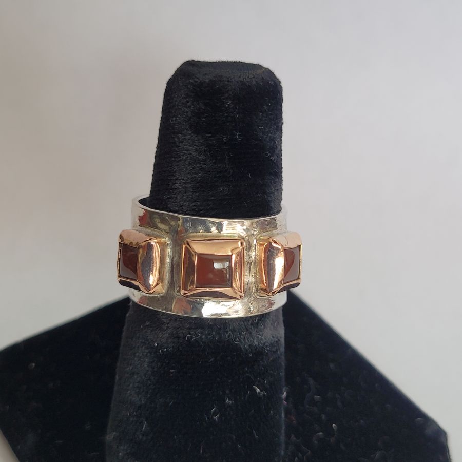 Handmade 14 carat gold and sterling silver gold Garnet ring contemporary style ring set with 3 Garnet stones and hand hammered silver.