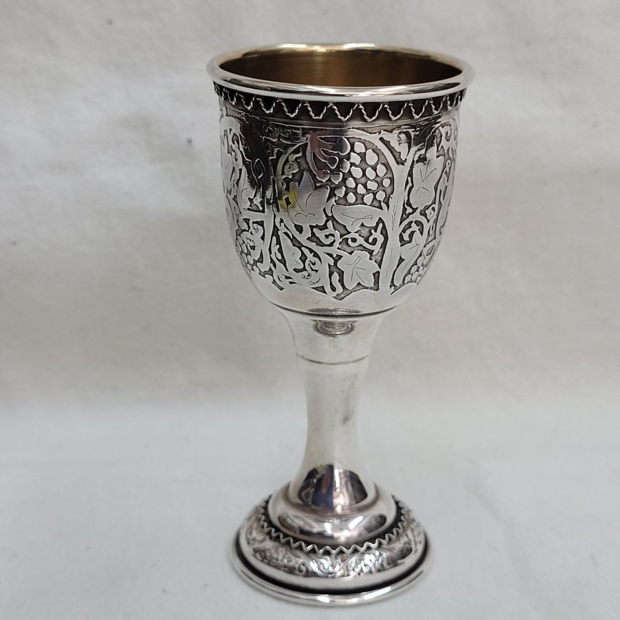 Sterling silver Schnapps cup etched designs of grapes all around. The Yemenite silversmith has added as well some filigree wires around base and top of cup.