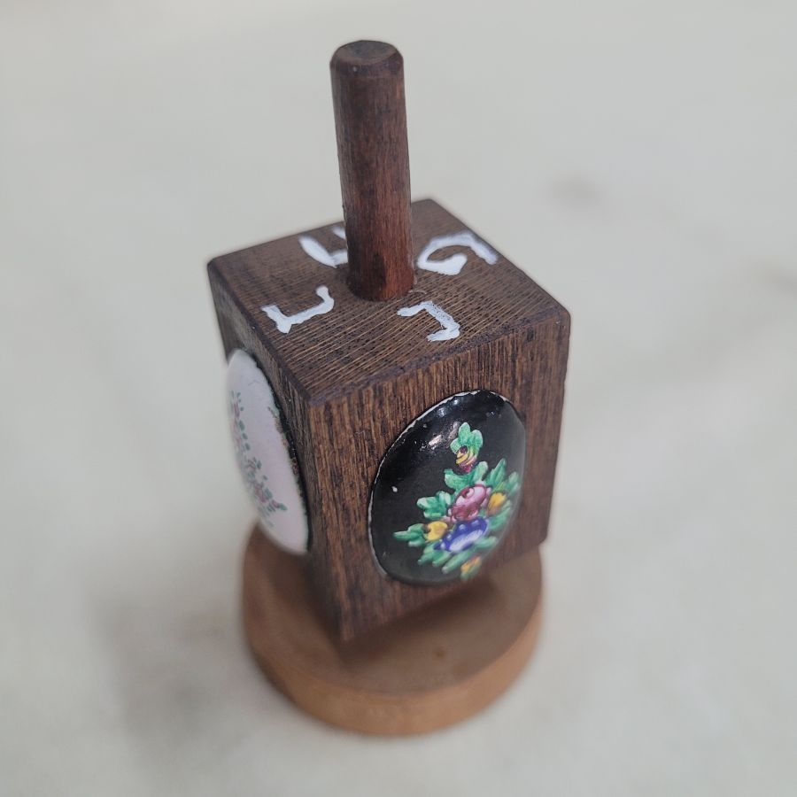 Handmade Hanukah Dreidel oval shape enameled with floral and birds designs on wood Dreidel. Dimension 3.7 cm X 3.7 cm X 7 cm approximately.
