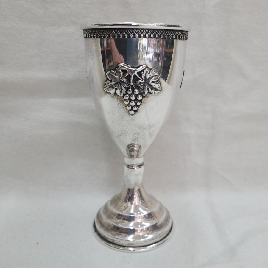 Sterling Silver Kiddush chalice wine grapes relief design with Yemenite filigree flower designs around border, diameter 6.5 cm X 14 cm approximately.