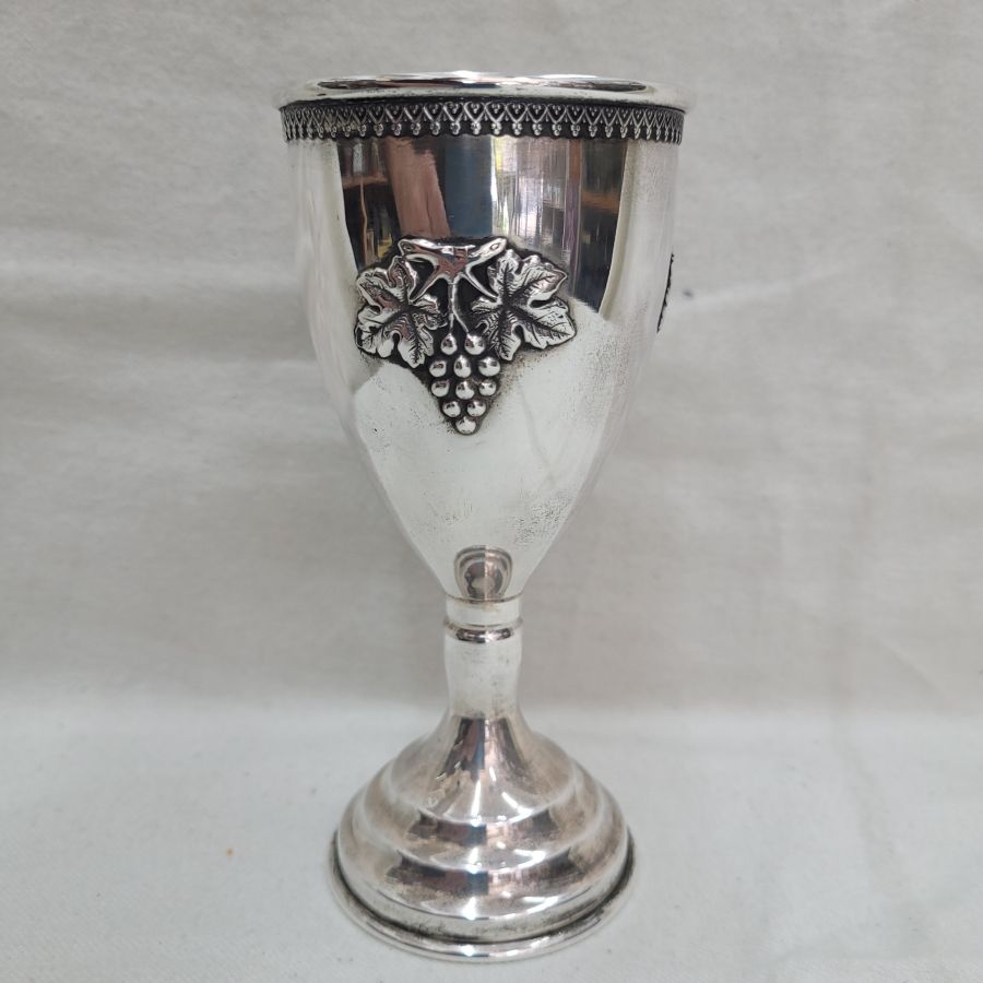 Sterling Silver Kiddush chalice wine grapes relief design with Yemenite filigree flower designs around border, diameter 6.5 cm X 14 cm approximately.